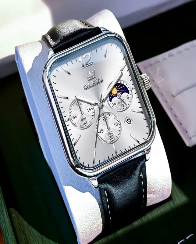 Luxury watch with black leather strap on a reflective surface