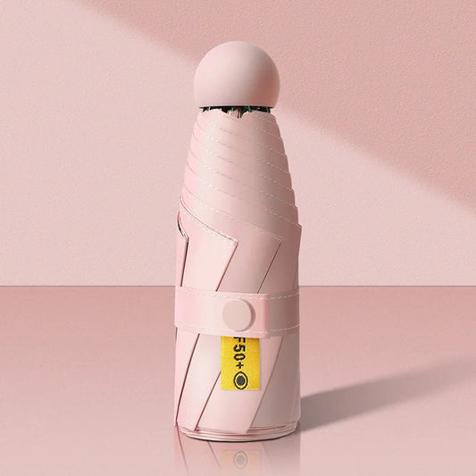 Pink umbrella folded and standing on a pink background