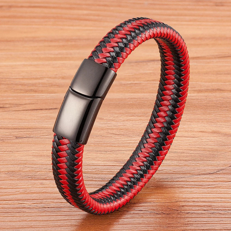 Red and black braided bracelet with a silver clasp on a wooden surface