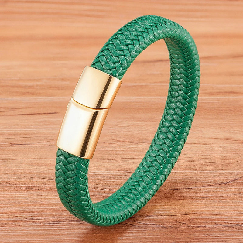 Green braided bracelet with a gold clasp on a wooden surface