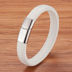 White braided bracelet with a silver clasp on a wooden surface
