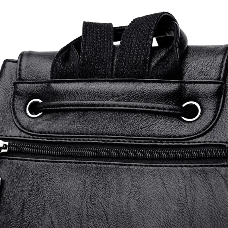 Close-up of a black leather bag with a zipper and strap on a white background