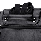 Close-up of a black leather bag with a zipper and strap on a white background
