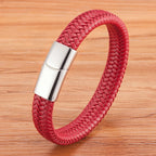 Red braided leather bracelet with a silver clasp on a wooden surface
