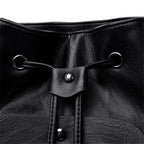 Close-up of a black leather drawstring bag with metal loops and buttons.