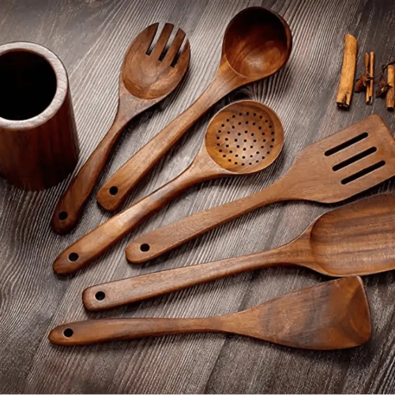 Set of wooden kitchen utensils on a wooden surface with text describing their properties.