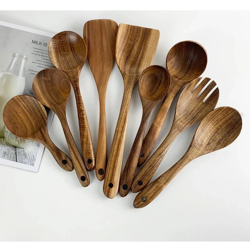 Set of wooden kitchen utensils including spoons and a fork on a white surface.