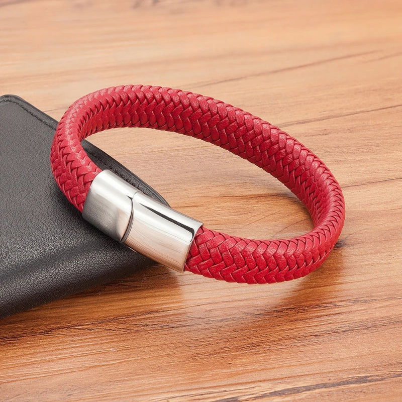 Red braided bracelet with a silver clasp on a wooden surface