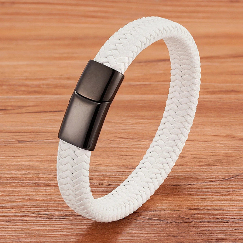 White braided bracelet with a black clasp on a wooden surface