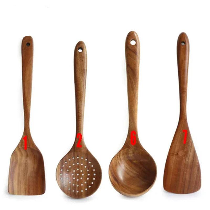 Set of four wooden kitchen utensils with handles on a white background