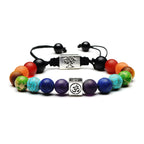 Multicolored beaded bracelet with black cord and silver charms on a white background