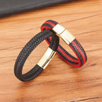 Black and red braided bracelet with gold clasp on a wooden surface