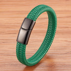 Green braided bracelet with a metallic clasp on a wooden surface