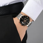 Person wearing a black watch with a blurred car in the background