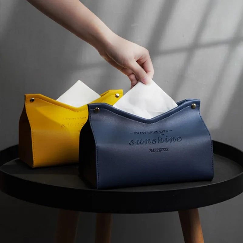 Two tissue holders, one yellow and one blue with 'sunshine' text, on a dark surface.