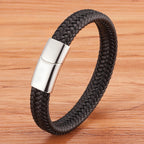 Black braided leather bracelet with a silver clasp on a wooden surface