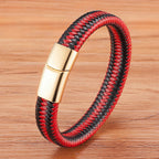 Red and black braided bracelet with a gold clasp on a wooden surface