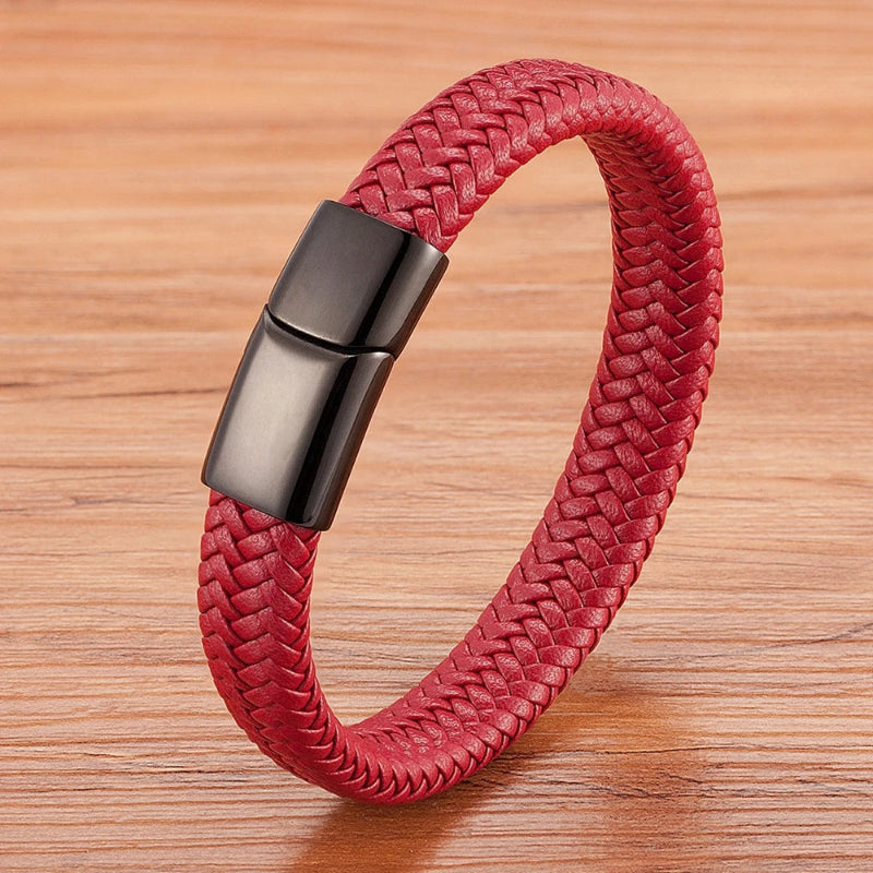 Red braided bracelet with a black clasp on a wooden surface