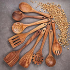 Set of wooden kitchen utensils on a gray surface with scattered lentils.