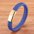 Blue braided bracelet with a gold clasp on a wooden surface