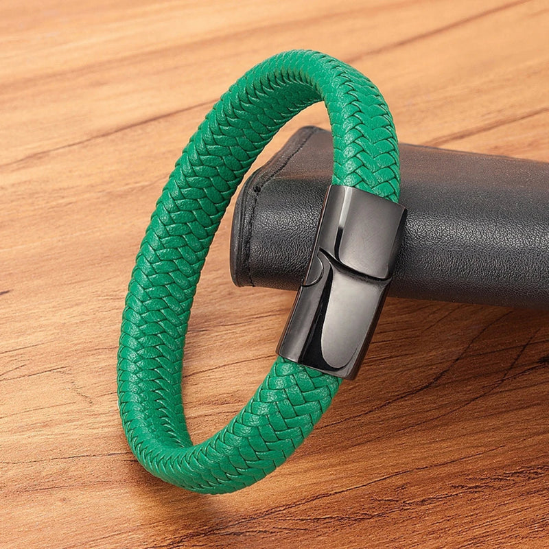 Green braided bracelet with a black clasp on a wooden surface