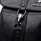 Close-up of a black leather bag with a silver zipper and brand logo.