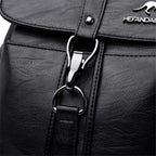 Close-up of a black leather bag with a silver zipper and brand logo.