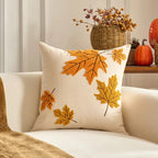 Decorative pillow with autumn leaf patterns on a couch