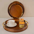 Wooden tray with a cup, saucer, and two cupcakes on a beige background
