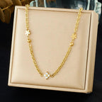 Gold necklace with floral pendants on a beige display box