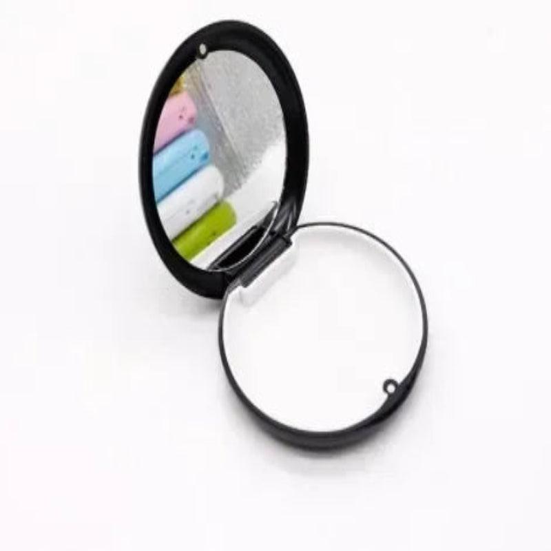Compact mirror with colorful items reflected on a white background