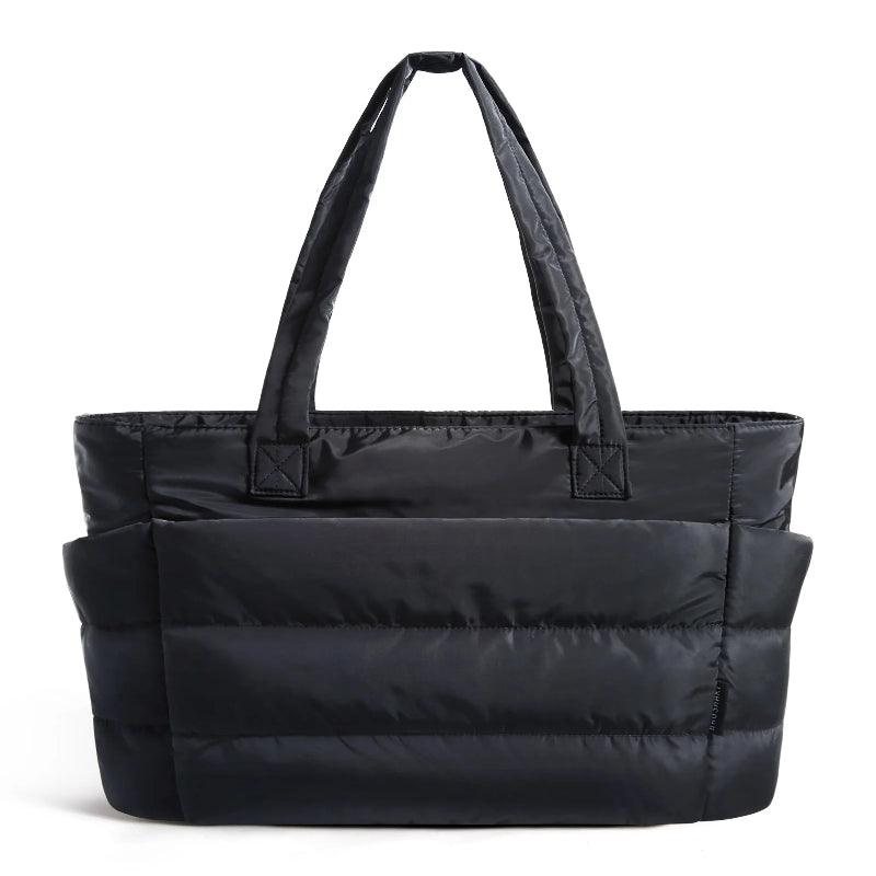 Black tote bag with multiple compartments on a white 