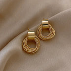 Gold hoop earrings on a beige fabric background