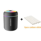 Black humidifier with colorful light and five cotton sticks on a white background