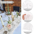 Table setting with floral arrangements and candles, featuring pleated sheer fabric details.