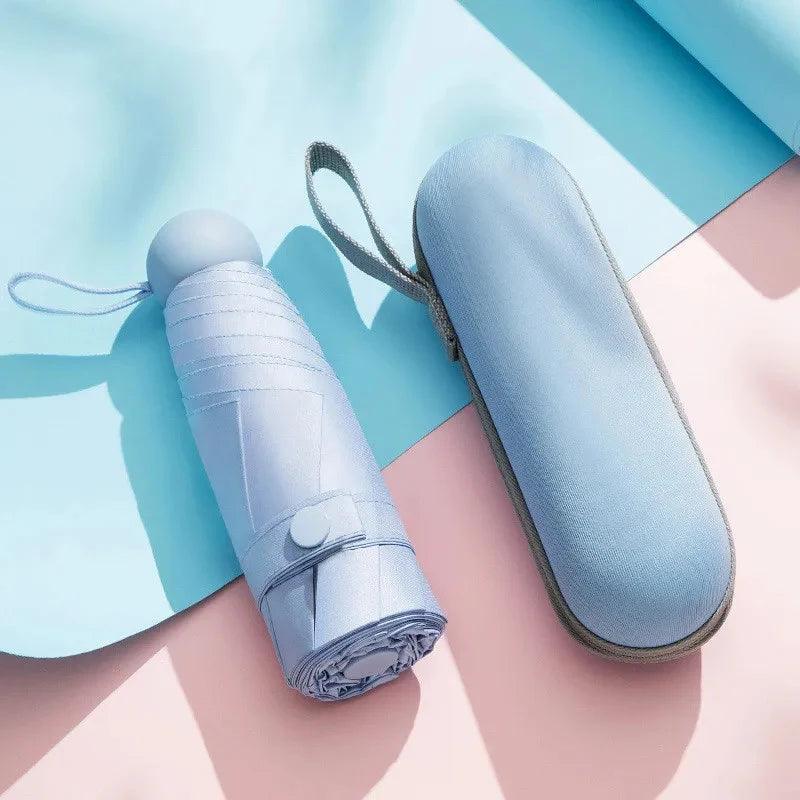 Foldable umbrella with carrying case on a light blue and pink background