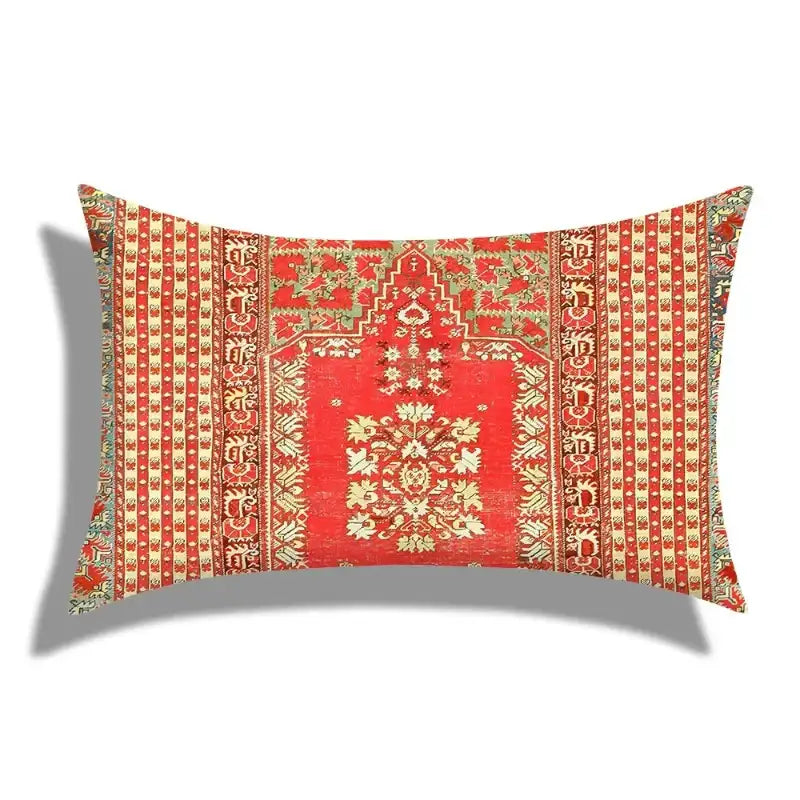 Decorative pillow with intricate red and gold pattern on a white background