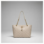 Beige handbag with gold chain strap hanging on a white door handle.