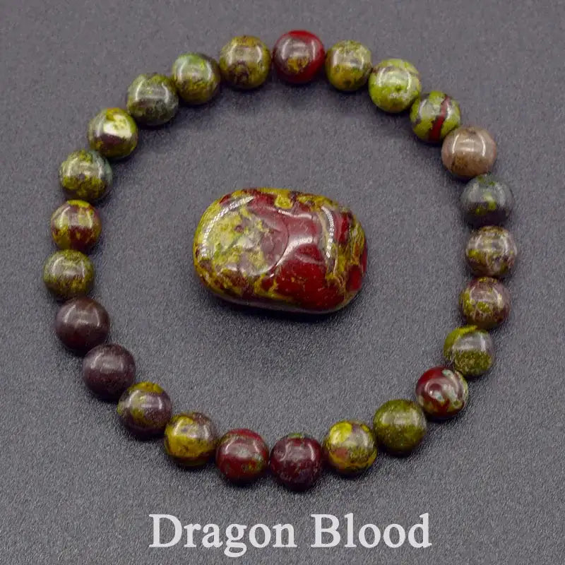 Dragon Blood stone and bracelet on a dark gray background