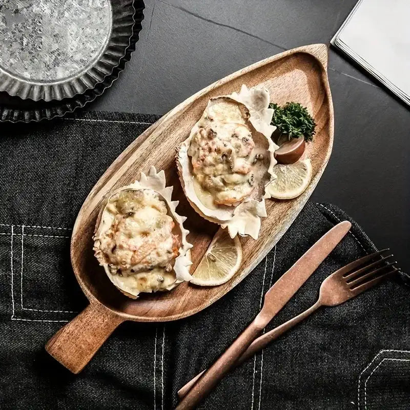Wooden plate with oysters on a dark surface with cutlery.