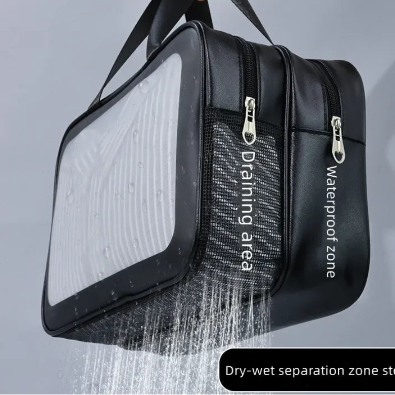 Black waterproof dry bag with a transparent front panel, shown being held by a hand with water spraying to demonstrate drainage. Features white text labels 'Draining area' and 'Waterproof zone' on the side, and a black label at the bottom reading 'Dry-wet separation zone storage'.