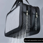 Black waterproof dry bag with a transparent front panel, shown being held by a hand with water spraying to demonstrate drainage. Features white text labels 'Draining area' and 'Waterproof zone' on the side, and a black label at the bottom reading 'Dry-wet separation zone storage'.