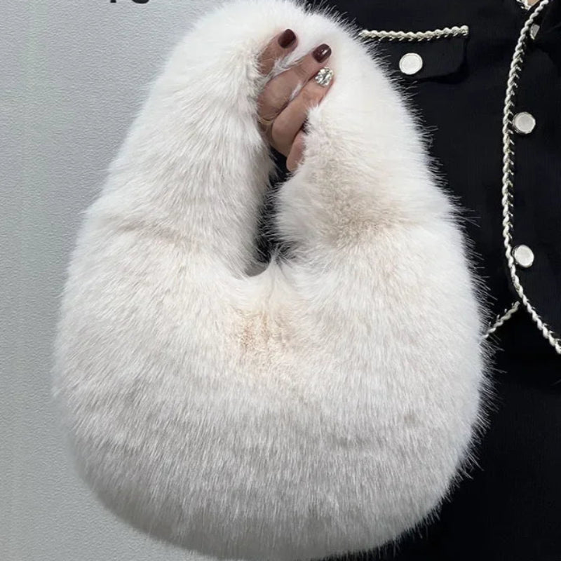 White fluffy bag held by a person wearing a black coat with white buttons against a gray background.