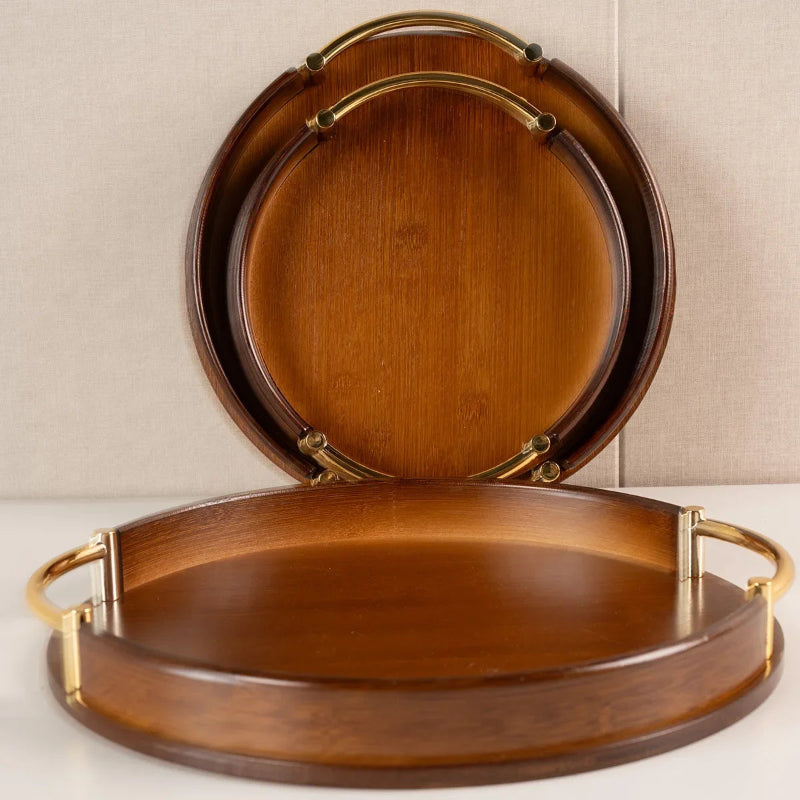 Two wooden trays with gold handles on a neutral background