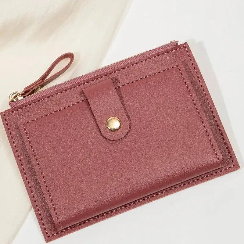 Pink purple wallet with a gold zipper on a light background