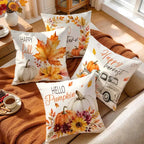 Four decorative throw pillows with autumn watercolor designs are arranged on a beige sofa with a rust-colored blanket. The pillows feature fall leaves, pumpkins, flowers, and phrases like 'Happy fall,' 'turn of the year,' 'Happy harvest,' and 'Hello Pumpkin.