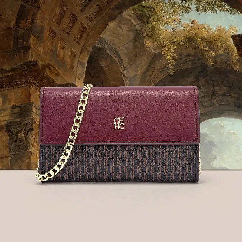 Purple handbag with gold chain strap in front of classical architecture