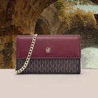 Purple handbag with gold chain strap in front of classical architecture