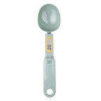 Digital measuring spoon with a light green handle and gray head on a white background