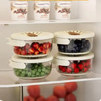 Stackable fruit storage containers with lids on a refrigerator shelf.